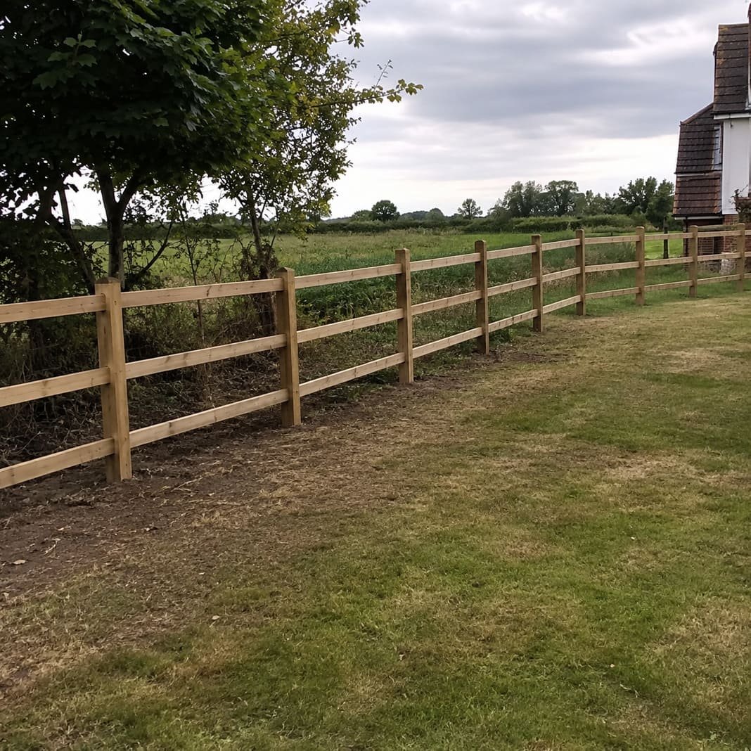 Post-and-rail fence in a larger rural garden.